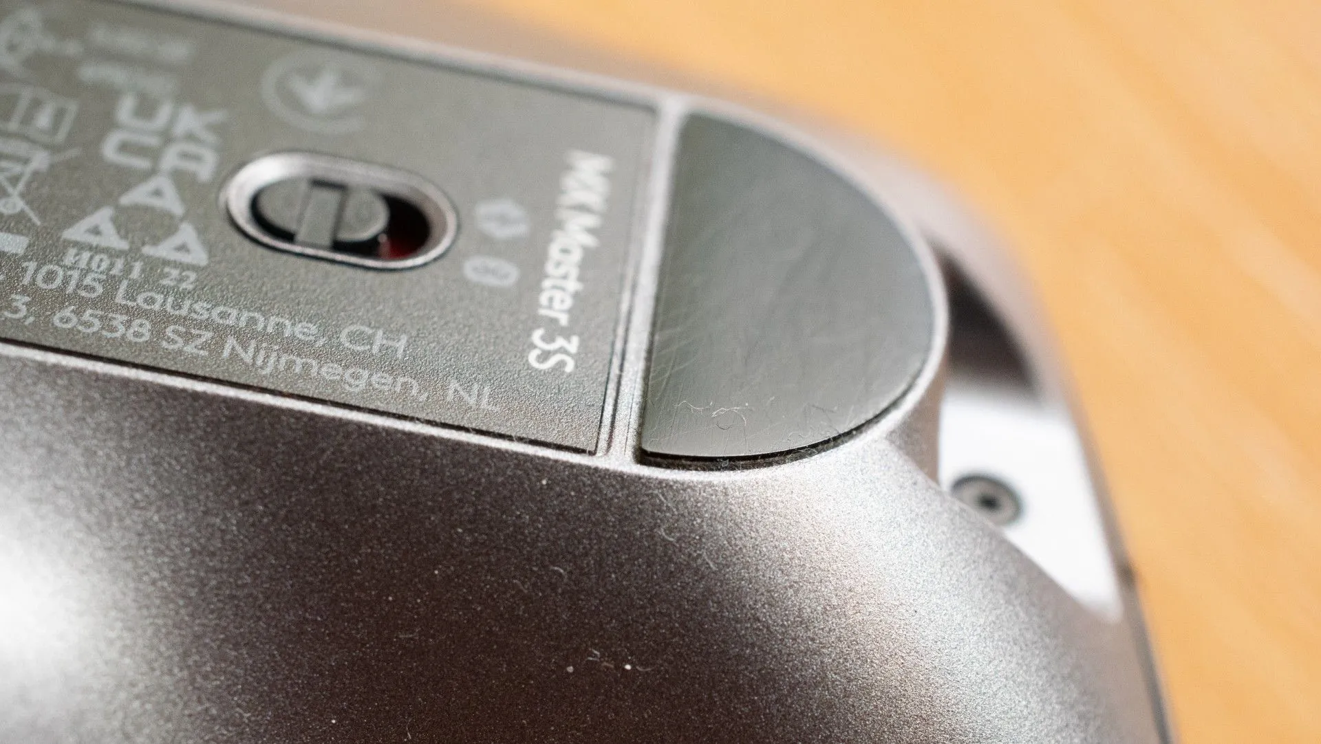Ảnh macro của đế chuột Logitech MX Master 3S, cho thấy vật liệu nhựa và các cạnh sắc gây ma sát, ảnh hưởng đến trải nghiệm di chuyển chuột, đặc biệt trên bàn di chuột vải.