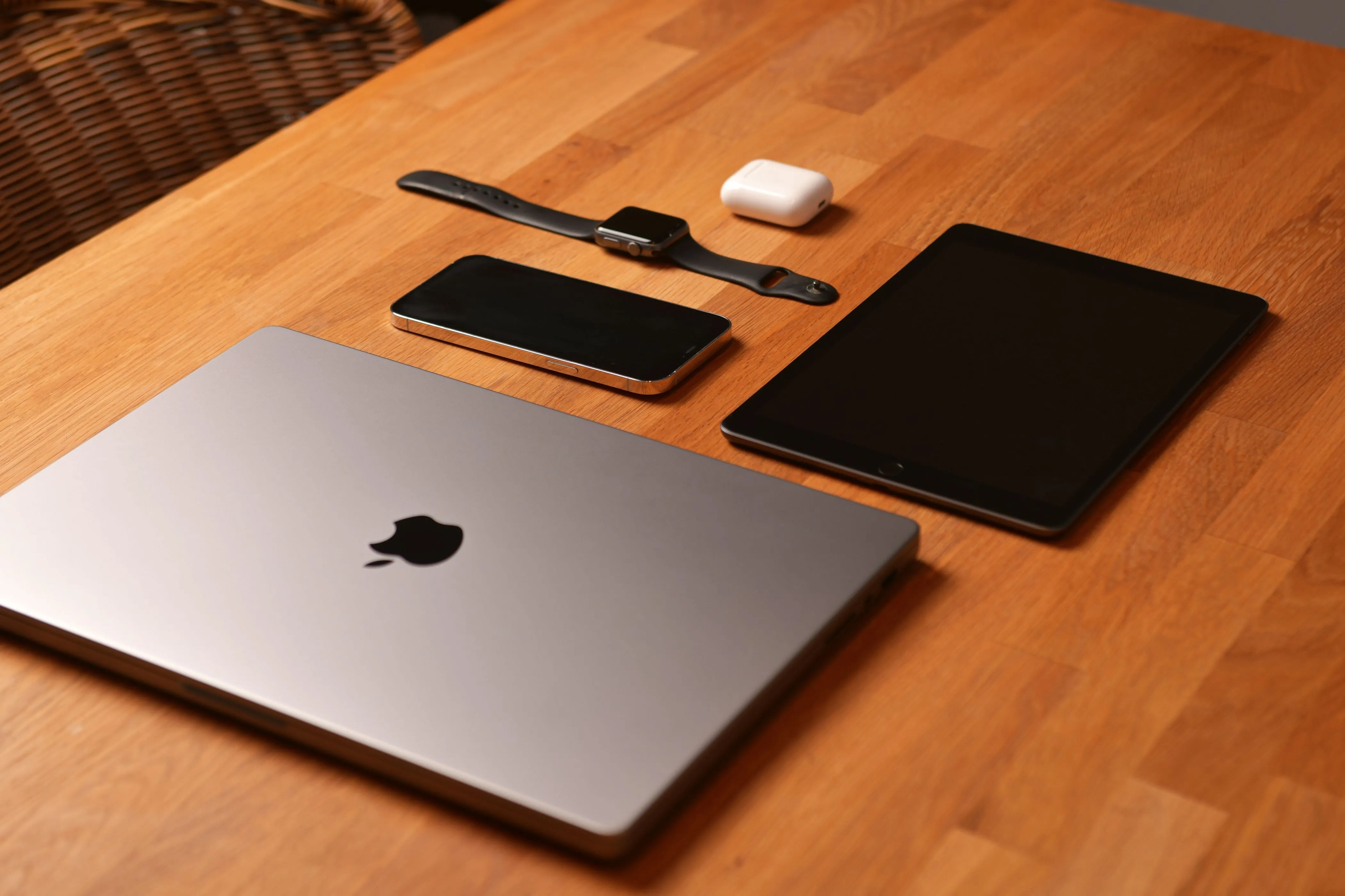 Các sản phẩm Apple đa dạng như MacBook, iPhone, iPad đặt trên bàn, thể hiện sự tích hợp chặt chẽ của hệ sinh thái Apple.