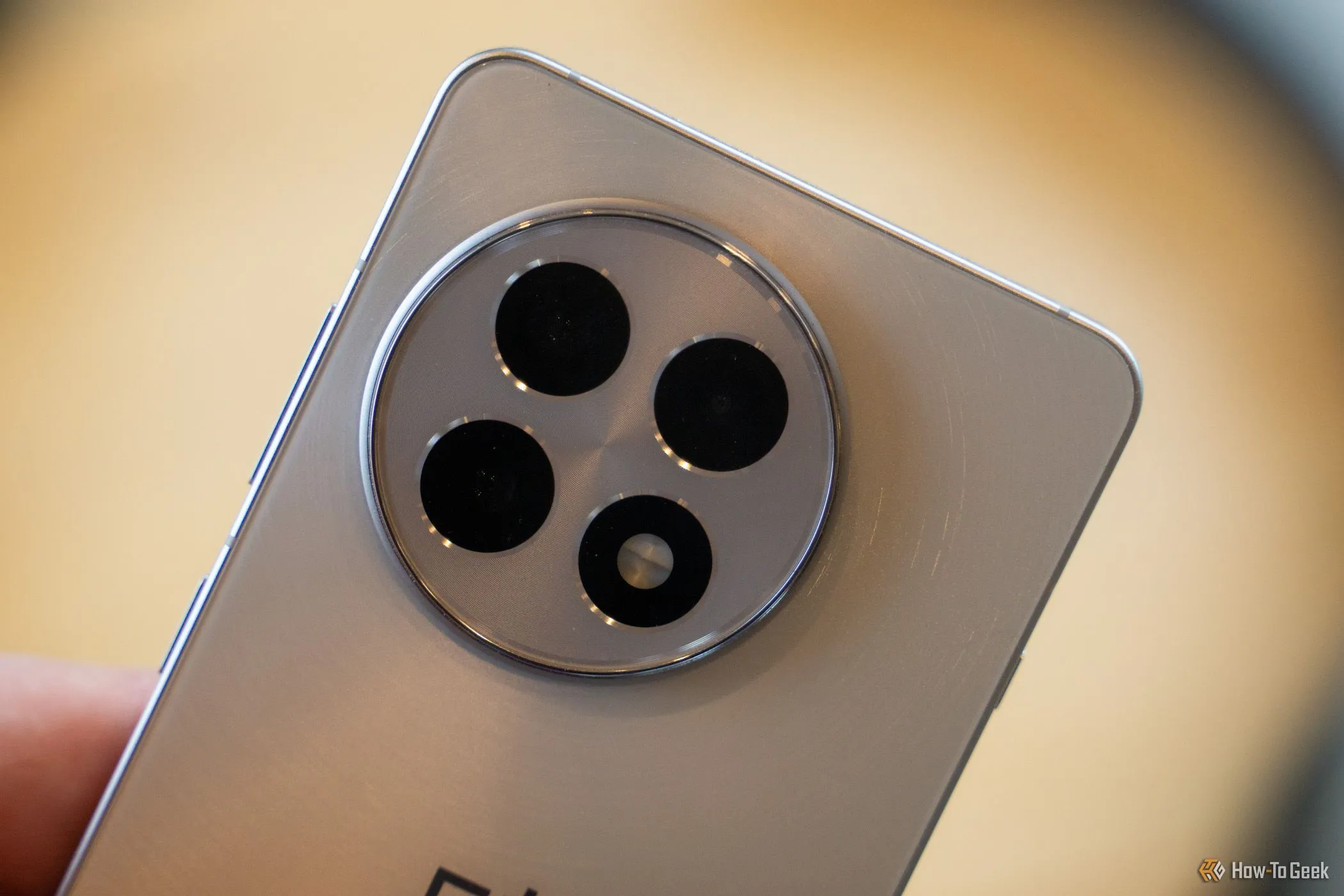 Cận cảnh cụm camera ba ống kính của điện thoại OnePlus 13R màu đen, nổi bật với thiết kế độc đáo và khả năng chụp ảnh chuyên nghiệp.