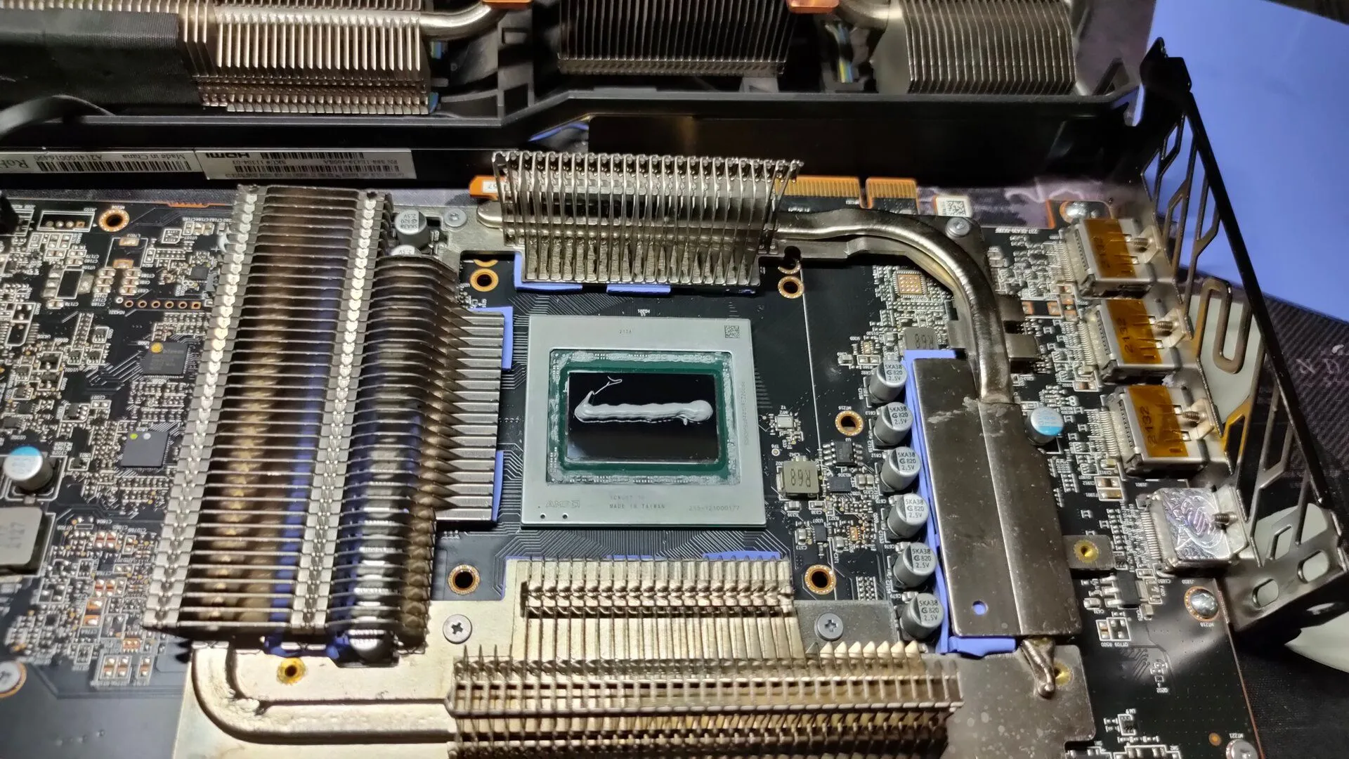 Card đồ họa AMD RX 6800 XT tháo rời với lớp keo tản nhiệt mới trên chip GPU, tượng trưng cho việc nâng cấp hoặc bảo trì card đồ họa trong hệ thống PC.
