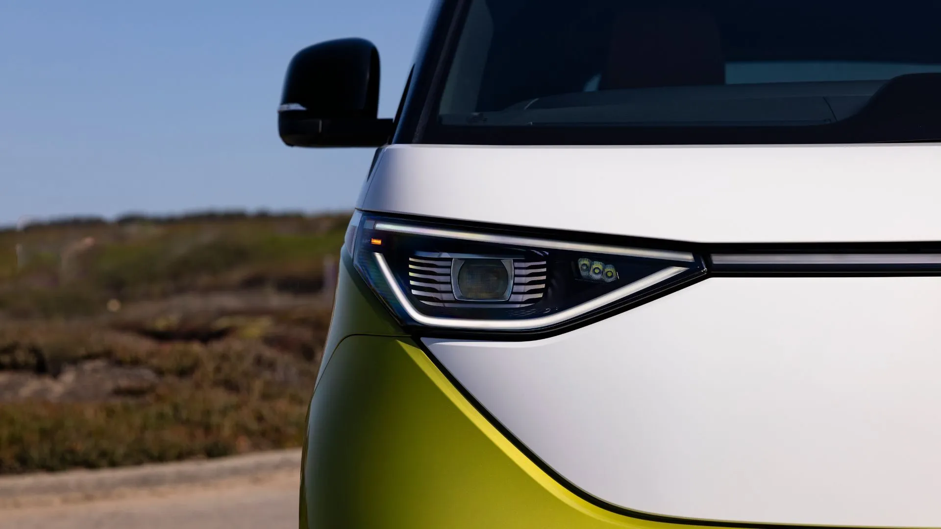 Đèn pha và mặt trước nổi bật của Volkswagen ID. Buzz 2025 màu vàng chanh, biểu tượng của sự kết hợp giữa thiết kế cổ điển và công nghệ xe điện hiện đại.