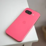 Điện thoại Google Pixel 9a màu đen bạc nằm trên mặt bàn, thể hiện thiết kế tối giản không có cụm camera lồi.