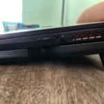 Laptop đặt trên tấm làm mát chủ động nhìn từ bên cạnh, minh họa cách tăng luồng khí cho hệ thống tản nhiệt laptop chơi game.