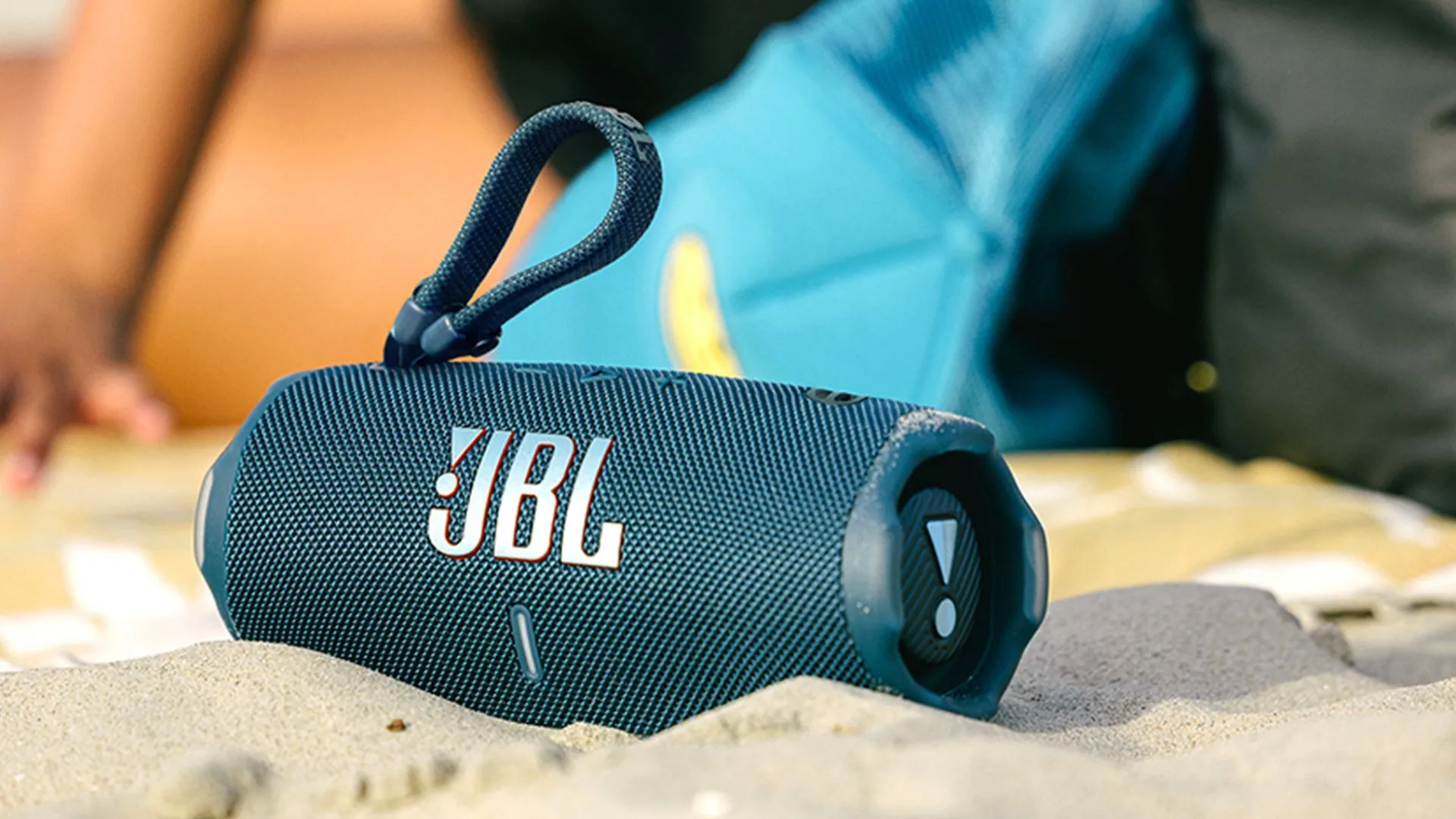 Loa Bluetooth di động JBL Charge 6 trên bãi cát, sẵn sàng cho những chuyến phiêu lưu mùa hè.
