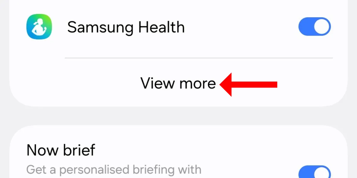 Màn hình cài đặt Now Bar trên Galaxy S25 với mũi tên chỉ vào tùy chọn &quot;Xem thêm&quot;, nơi người dùng có thể tùy chỉnh thông báo trực tiếp.