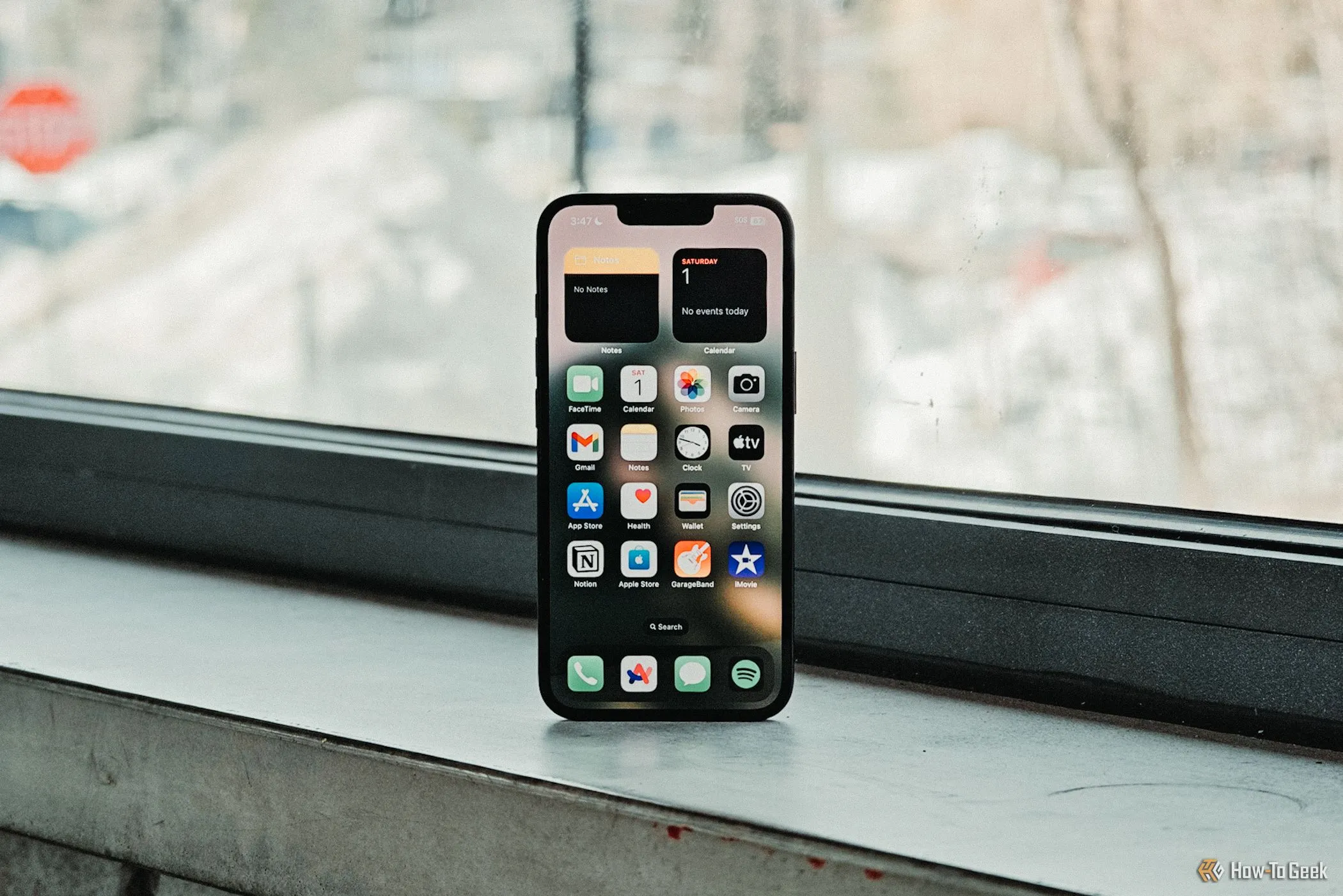 Màn hình chính iPhone 16e hiển thị sống động trước cửa sổ, làm nổi bật chất lượng tấm nền Super Retina XDR và độ sáng của màn hình.