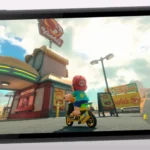 Màn hình Switch 2 hiển thị hình ảnh game Mario lái xe scooter với đồ họa sắc nét.