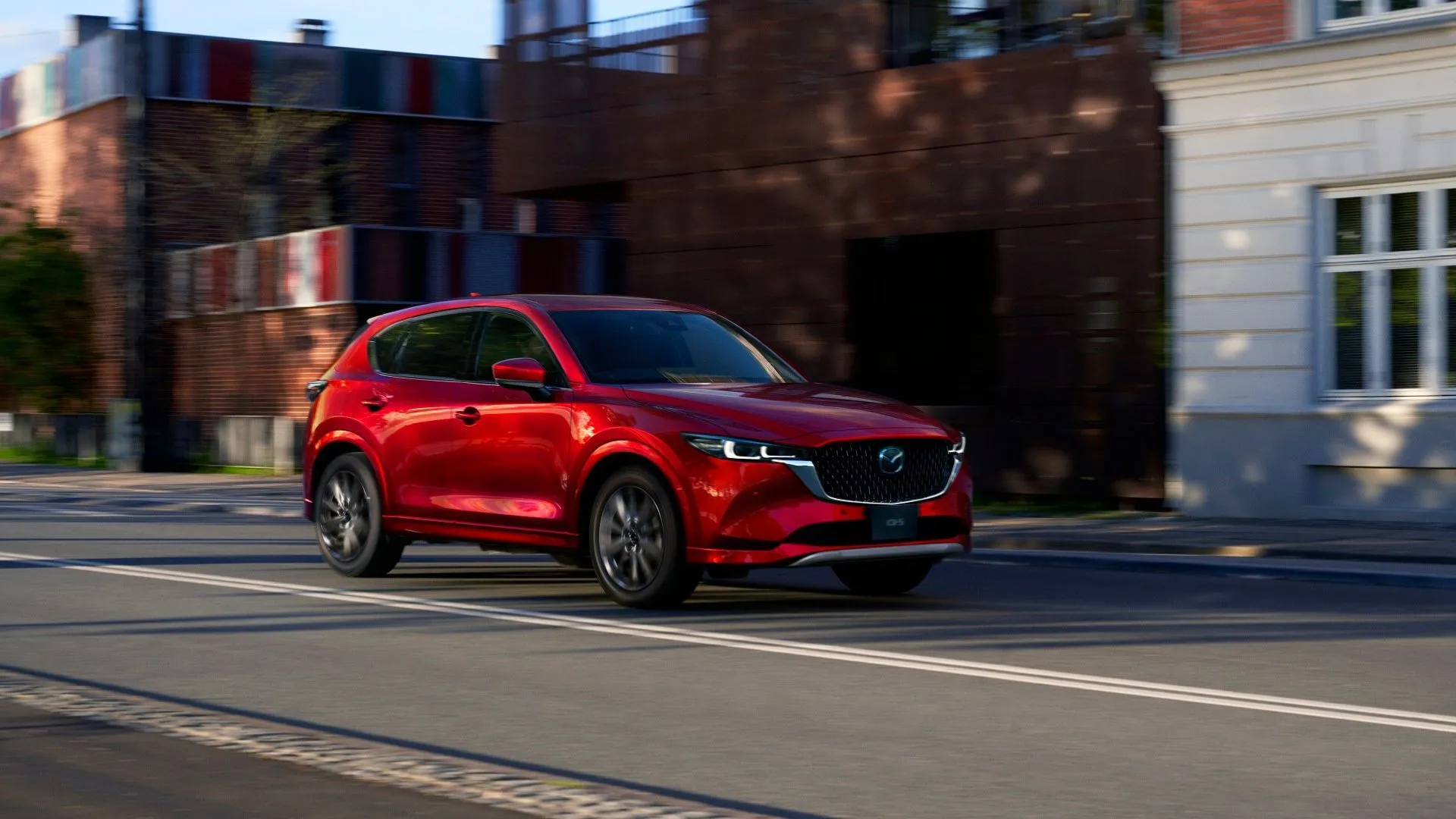 Mẫu xe SUV Mazda CX-5 thế hệ mới màu đỏ đang di chuyển trên đường, đại diện cho việc sử dụng động cơ Skyactiv-Z