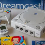 Máy chơi game Sega Dreamcast màu trắng với tay cầm, VMU và đĩa game Space Channel 5, tượng trưng cho một kỷ nguyên vàng son của console retro.
