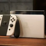Mô hình máy chơi game Nintendo Switch OLED màu trắng với Joy-Con trắng, hiển thị màn hình sáng rõ.