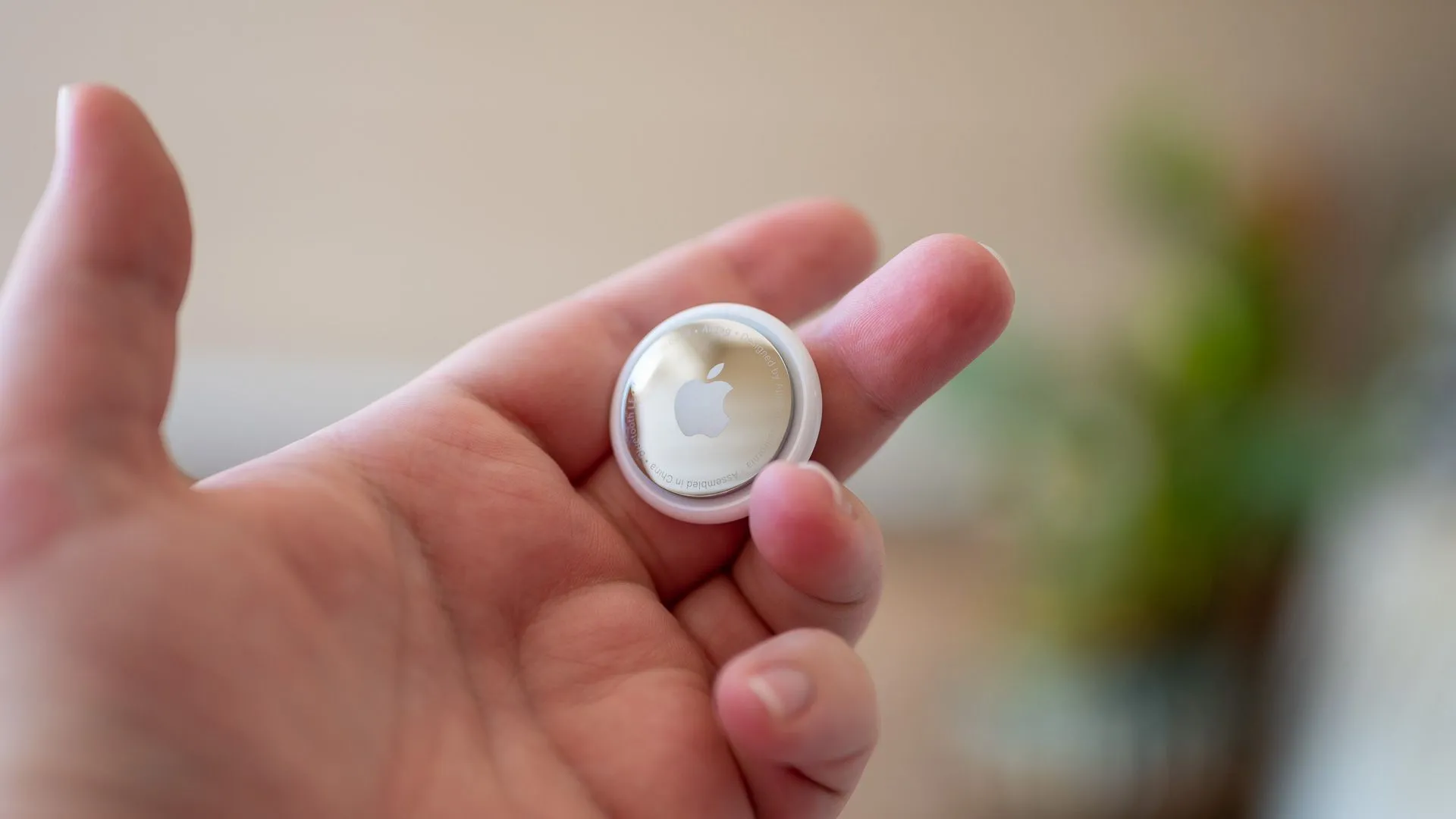 Một người đang cầm một chiếc Apple AirTag trên tay