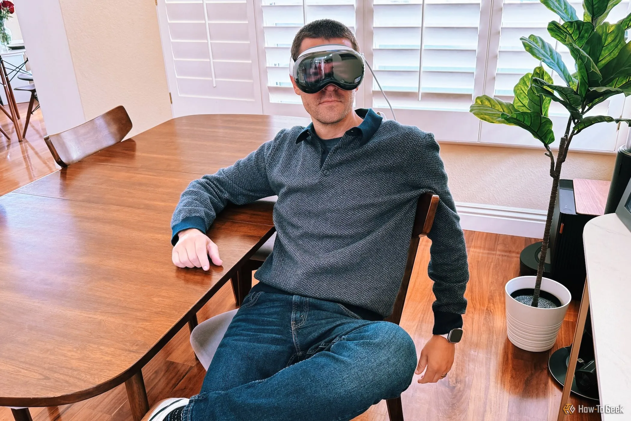 Một người đang đeo kính Apple Vision Pro và ngồi trên ghế sofa