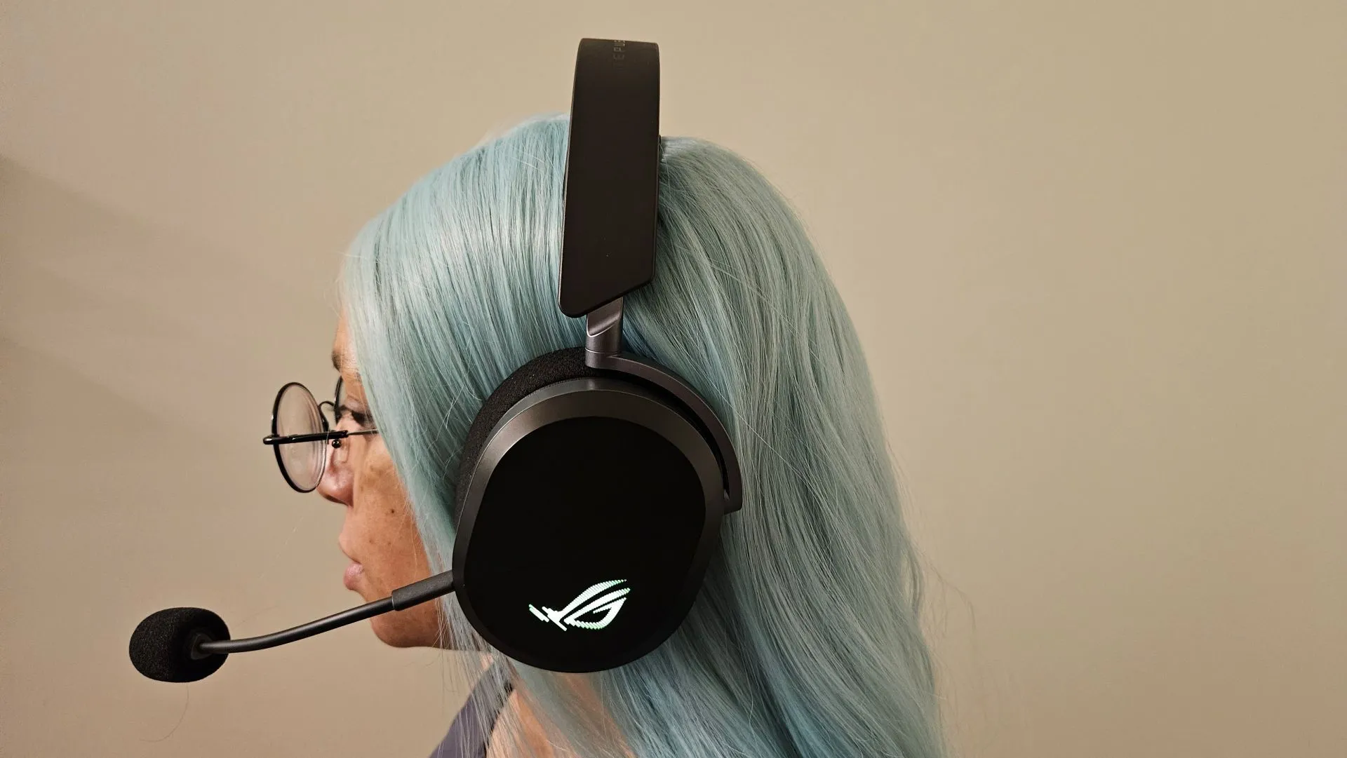 Một người phụ nữ đang đeo tai nghe gaming ASUS ROG Pelta, minh họa thiết kế nhẹ nhàng và thoải mái khi sử dụng lâu dài.