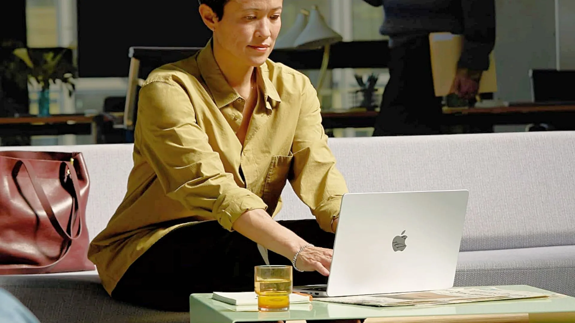 Một người phụ nữ đang làm việc trên MacBook Pro 14 inch M4 đặt trên bàn, thể hiện sự chuyên nghiệp và hiệu quả cho công việc hàng ngày.