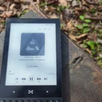 Một tập podcast đang phát trên điện thoại Minimalist, minh họa sự phổ biến của việc nghe podcast mọi lúc mọi nơi.