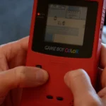 Người chơi đang trải nghiệm game Pokemon Yellow trên máy Game Boy Color, minh họa cho đồ họa và công nghệ đơn giản của các phiên bản Pokemon cổ điển.