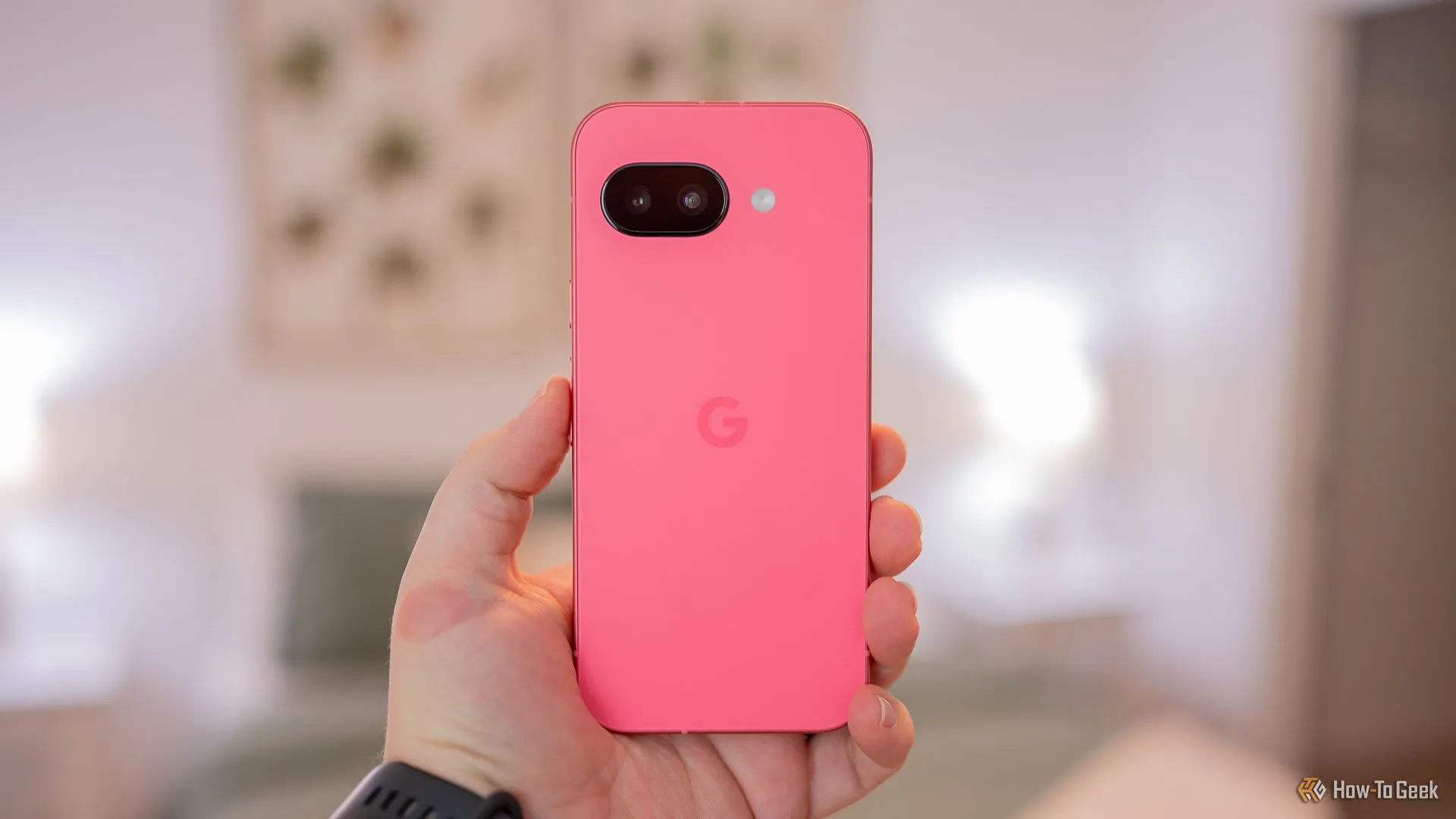 Người dùng cầm điện thoại Google Pixel 9a, làm nổi bật mặt lưng với thiết kế phẳng và cụm camera mới, không còn thanh camera ngang.