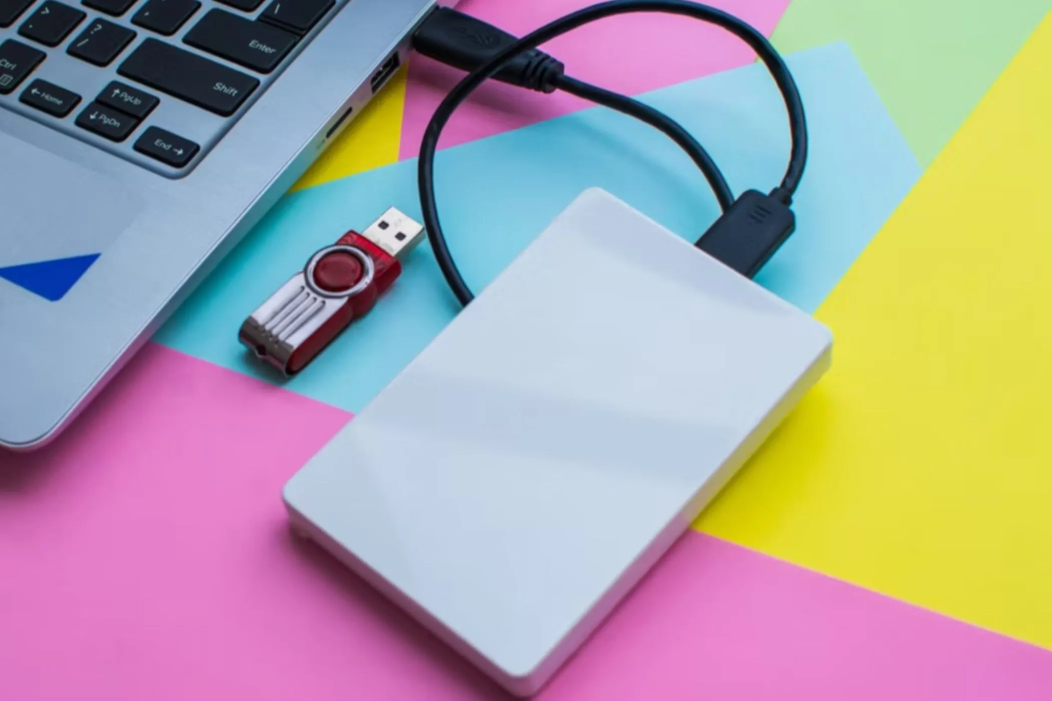 Ổ đĩa flash USB và ổ cứng gắn ngoài được kết nối với máy tính xách tay, thể hiện phương pháp chuyển nhạc từ đĩa CD thông qua thiết bị lưu trữ di động.