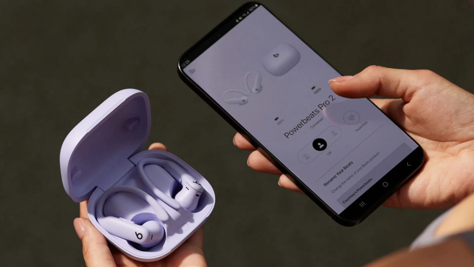 Tai nghe Powerbeats Pro 2 màu đen bên cạnh điện thoại Android, thể hiện sự kết hợp hoàn hảo cho người dùng tìm kiếm thời lượng pin dài và tương thích đa nền tảng.