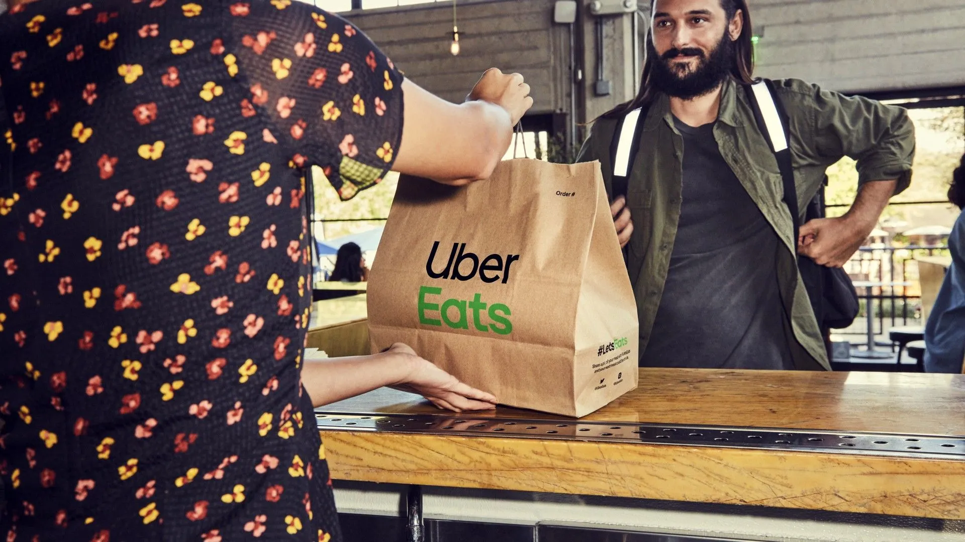 Tài xế Uber Eats nhận túi đồ ăn từ nhà hàng để giao cho khách hàng.