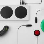 Tay cầm Xbox Adaptive Controller kết nối với joystick, nút bấm lớn và các phụ kiện hỗ trợ người khuyết tật.