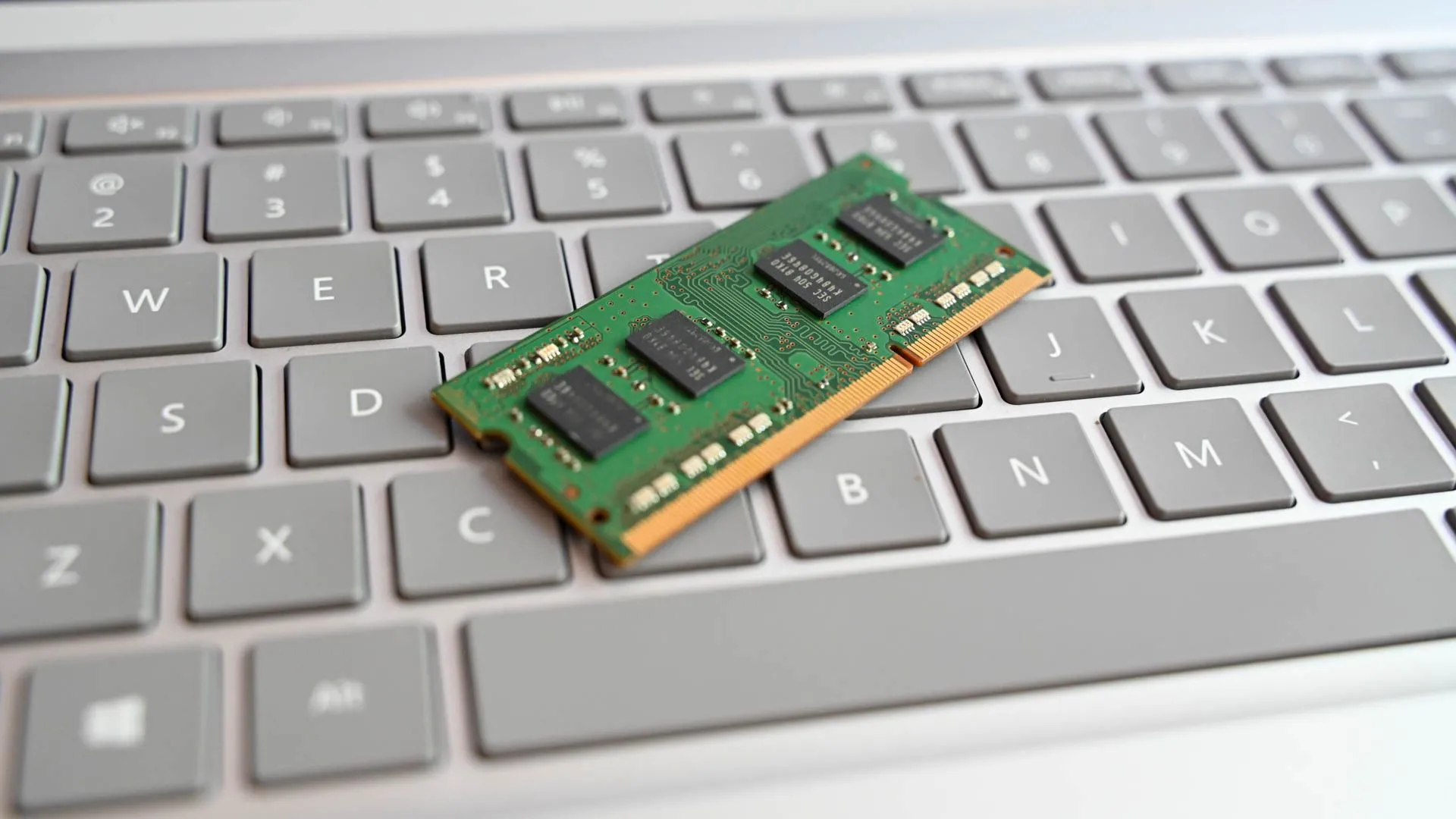Thanh RAM laptop đặt trên bàn phím, biểu tượng cho khả năng nâng cấp bộ nhớ của máy tính mini, quan trọng để chạy nhiều ứng dụng cùng lúc với Plex.
